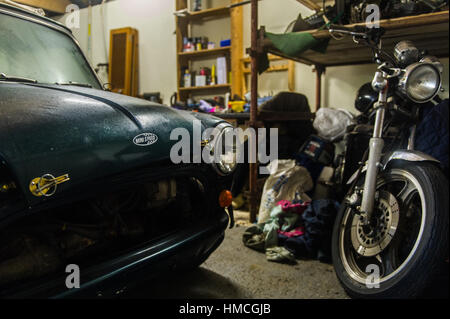 Classic Austin Mini Cooper e Kawasaki moto in un garage interno/workshop. Foto Stock