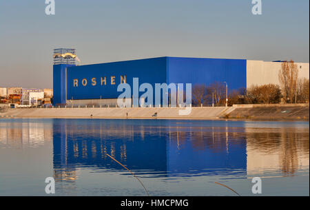 VINNITSA, Ucraina - 2 Aprile 2014: persone non riconosciuto la pesca nel sud del fiume Bug di fronte Roshen dolciumi edificio. Roshen proprio in fabbrica Foto Stock