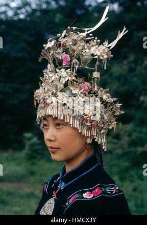 Una ragazza che indossa un copricapo tradizionale, Miao persone, Cina. Foto Stock