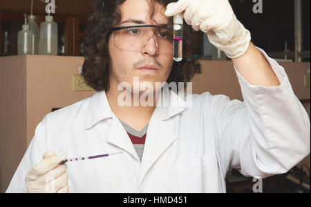 Close up giovane farmacista di miscelazione del reagente di colore in lab Foto Stock
