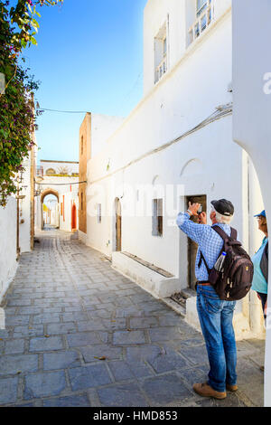 Giovane a piedi il bianco lavato strade di Lindos, Rodi, Grecia Foto Stock