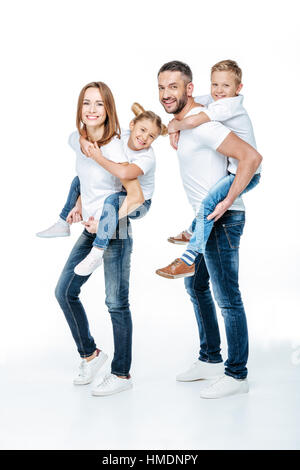 Piggybacking i genitori dei bambini felici Foto Stock