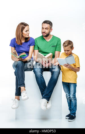 Famiglia con un bambino la lettura di libri Foto Stock