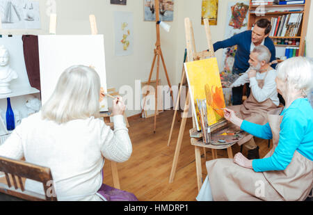 Gruppo di persone aventi una lezione nella scuola di pittura Foto Stock