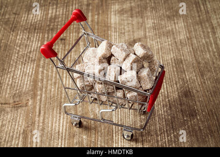 Carrello pieno di colore marrone zucchero di canna su sfondo di legno Foto Stock