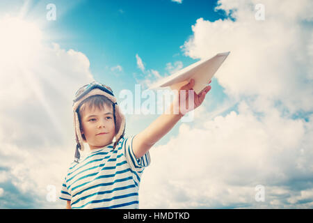 Ragazzo giocando con un aeroplano di carta in aviator hat Foto Stock