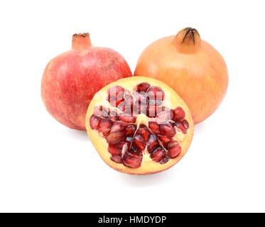 Due interi melagrane e a tagliare la metà che mostra i semi, isolato su uno sfondo bianco Foto Stock