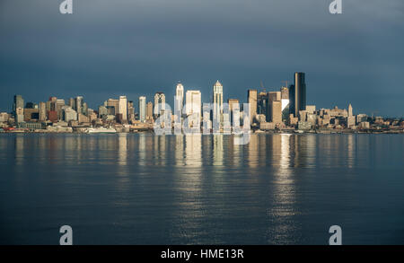 Come il sole tramonta edifici della skyline di Seattle sono riflesse nella Baia di Elliott. Foto Stock