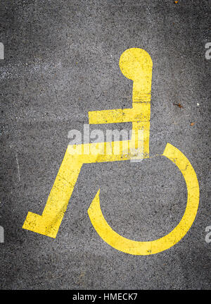 Simbolo della carrozzella in un parcheggio disabili contrassegni di parcheggio. Iconon bianco blu quadrata in metallo segno. Foto Stock