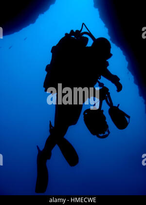 Silhouette di fotografo subacqueo nella parte anteriore della grotta sottomarina uscire Foto Stock