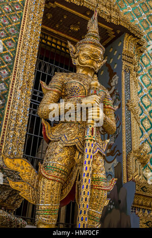 Imponenti statue a guardia di un edificio ingresso in Wat Phra Kaew, a Bangkok (Thailandia) Foto Stock