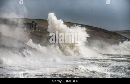 Porthleven Harbour, tempesta in Cornovaglia con grandi onde che colpiscono le scogliere In Cornovaglia Foto Stock