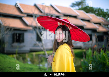 Donna Thai medicazione con ombrello stile tradizionale Foto Stock