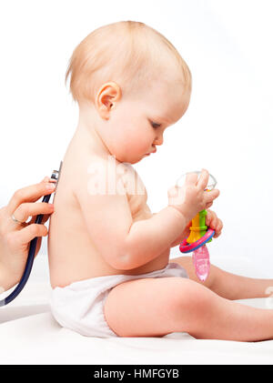 Pediatra esamina little Baby girl utilizzando uno stetoscopio per ascoltare il bambino indietro controllando il battito cardiaco Foto Stock