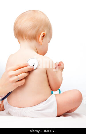 Pediatra esamina little Baby girl utilizzando uno stetoscopio per ascoltare il bambino indietro controllando il battito cardiaco Foto Stock