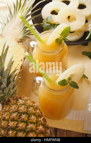 Spremuta di succo di ananas in un vasetto di vetro closeup sul piano verticale. Foto Stock
