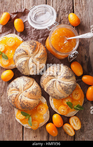 Panini dolci con kumquat marmellata e crema di formaggio vicino sul tavolo. vista verticale da sopra Foto Stock