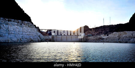 Lake Mead National Recreation Area, Nevada, Stati Uniti d'America. Xii gen, 2016. La diga di Hoover e il Mike O'CallaghanÃPat Tillman Memorial Bridge è visto al tramonto sul Lago Mead Martedì, Gennaio 12, 2016. Come una lunga siccità continua, un bianco "vasca" ad anello è formata da depositi di minerali a sinistra dopo che l'acqua si abbassarono. Credito: David Becker/ZUMA filo/Alamy Live News Foto Stock