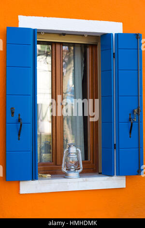 La Lampada sul davanzale con finestra blu scuri della casa - colori luminosi di Burano Venezia Italia nel mese di gennaio Foto Stock