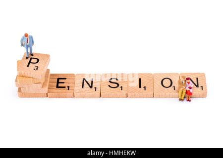 Scrabble lettere costituiscono la parola PENSIONE. Un uomo si erge sulla cima della lettera P della pensione, mentre una coppia di anziani sedersi alla fine sulla lettera N. Foto Stock