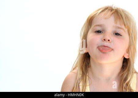 Ragazza giovane ragazzo biondo bambino facendo una faccia buffa con la lingua fuori divertendosi Foto Stock