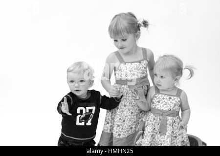 I bambini tenendo le mani insieme e in bianco e nero, dolce bambini innocenti giocando, bionda divertente concetto, collegati insieme e per il divertimento di tutta la famiglia dolcezza carino Foto Stock