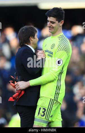 Chelsea portiere Thibaut Courtois (destra) e Chelsea manager Antonio Conte dopo il fischio finale durante il match di Premier League a Stamford Bridge, Londra. Foto Stock
