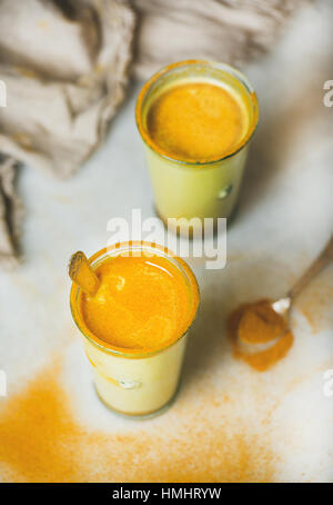 Golden latte con la curcuma in polvere in bicchieri, naturale flu Remedy Foto Stock