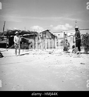 Fischer mit Fischernetz und kleiner Junge am Ufer der Isla Margarita, Venezuela 1966. Pescatore con canna un ragazzino presso la costa di Isla Margarita, Venezuela 1966. Foto Stock