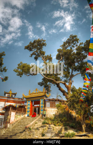 Swayambhunath monaco seduto sui gradini del tempio. Il Nepal. Asia architettura. Foto Stock