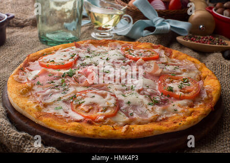 Pizza con prosciutto formaggio e pomodori Foto Stock