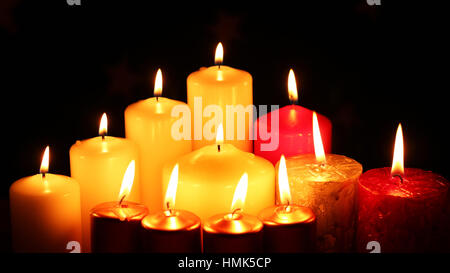 Molte candele multicolori illuminati tenebre Foto Stock