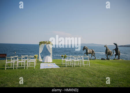 Cerimonia di nozze fiori, arco, sedie con il Mar Nero in background. Matrimonio sulla spiaggia Foto Stock