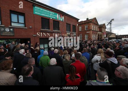 Sinn Fein leader Gerry Adams (destra) parla durante un evento commemorativo a Sinn Fein cade della sede stradale per ricordare tre Partito dei lavoratori che sono stati uccisi in ufficio 25 anni fa. Foto Stock