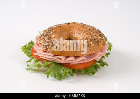 Bagel sandwich con prosciutto su sfondo bianco Foto Stock