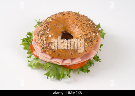 Bagel sandwich con prosciutto su sfondo bianco Foto Stock