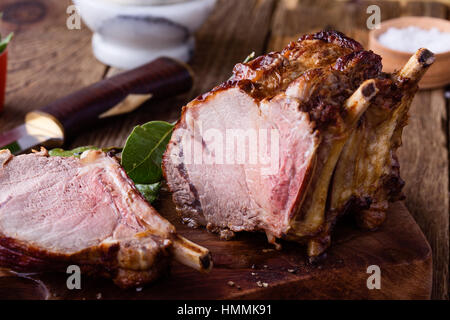 In casa con osso prime rib roast su tavola in legno rustico Foto Stock