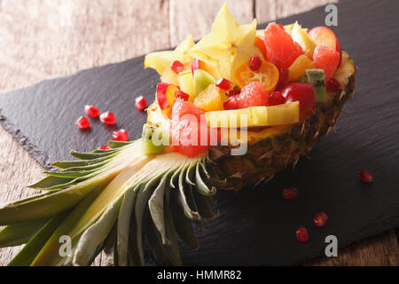 Ananas ripieni con freschi frutti esotici vicino sul tavolo orizzontale. Foto Stock