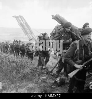 D-giorno 6 giugno 1944. Royal Marine Commando attaccata alla terza divisione di fanteria spostando la navigazione da una spada Beach con un bridgelayer in background. Foto: funzionario britannico Foto Stock