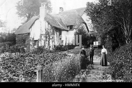 MARSTON, DEVON cottage con il tetto di paglia con alveari in giardino su una cartolina 1905 Foto Stock