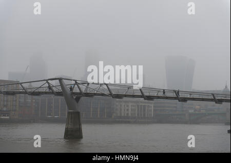 Londra, Regno Unito. 10 Febbraio, 2017. Bassa visibilità con edifici alti oscurata, pioggia e vento amaro in grigio Londra centrale. I pedoni attraversano il Millennium footbridge con la City di Londra grattacieli nascosti nella nebbia. Credito: Malcolm Park editoriale/Alamy Live News Foto Stock