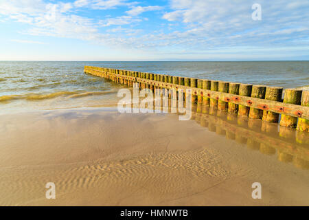 I frangiflutti in legno sulla spiaggia Leba durante la giornata di sole con le nuvole, Mar Baltico, Polonia Foto Stock