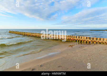 I frangiflutti in legno sulla spiaggia Leba durante la giornata di sole con le nuvole, Mar Baltico, Polonia Foto Stock