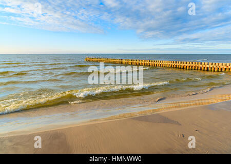 I frangiflutti in legno sulla spiaggia Leba durante la giornata di sole con le nuvole, Mar Baltico, Polonia Foto Stock