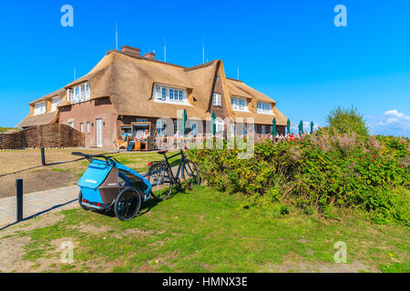 Isola di Sylt, Germania - SET 9, 2016: bici con il bambino rimorchio parcheggiato di fronte ristorante edificio vicino Monsur cliff, isola di Sylt, Germania. Foto Stock