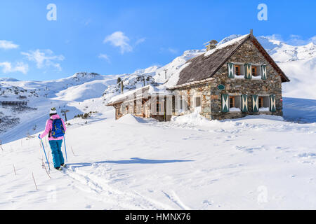 Donna giovane sciatore oltrepassando baita di montagna a Obertauern winter resort, Austria Foto Stock