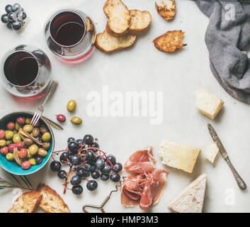 Formaggio, olive, uva, prosciutto, baguette alla brace e vino rosso Foto Stock