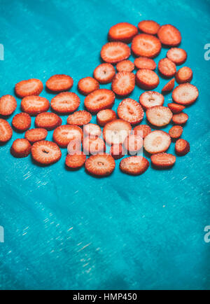Cuore di fragole fresche su blu brillante background verniciato Foto Stock
