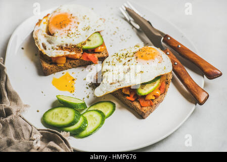 La colazione brinda con verdure fresche e uova fritte su piastra Foto Stock