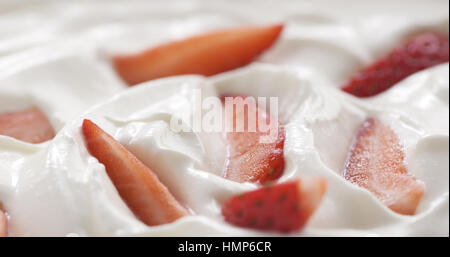 Fresco affettato straberries in background di crema Foto Stock
